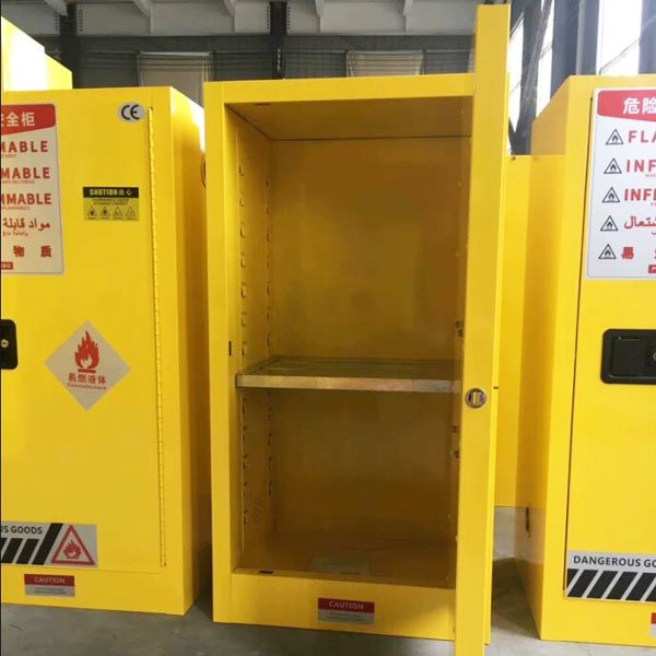 22 gallon yellow flammable safety cabinet in industrial factory workshop next to workbench